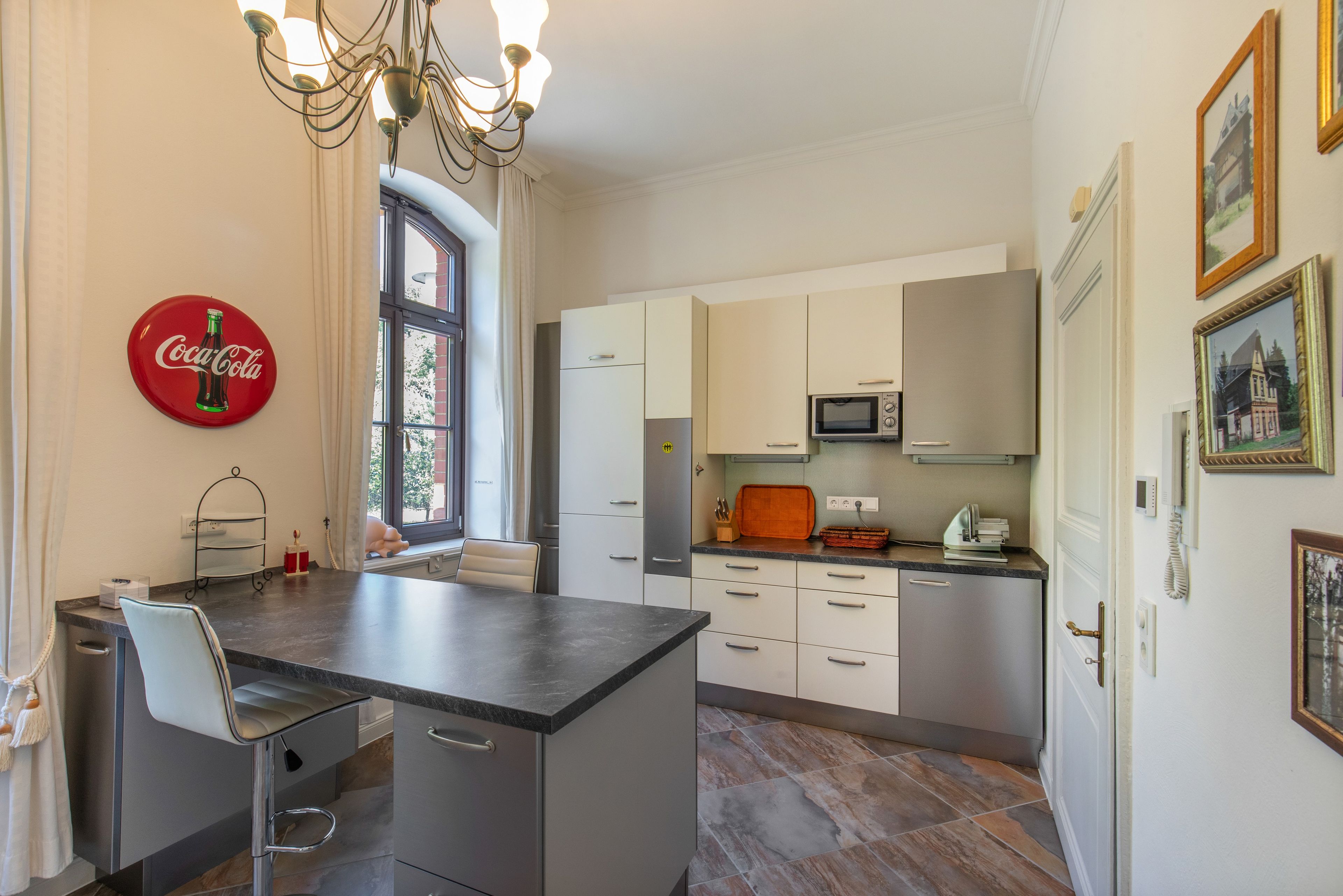 A modern kitchen with a central island, built-in appliances, and a dining area.