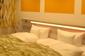 A neatly made bed with white bedding and pillows, a wooden headboard, and a wall with three orange panels. - Bernstein Suite DUKE ALBRECHT (Oberstdorf)