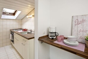 A kitchen with a built-in oven, a coffee maker, and a wall-mounted sign. - Holiday apartment with 3 bedrooms (Füssen)