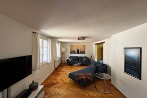 A modern living room with a sofa, TV, and a framed picture on the wall. - Holiday home in Lindau with swimming pool (Lindau)