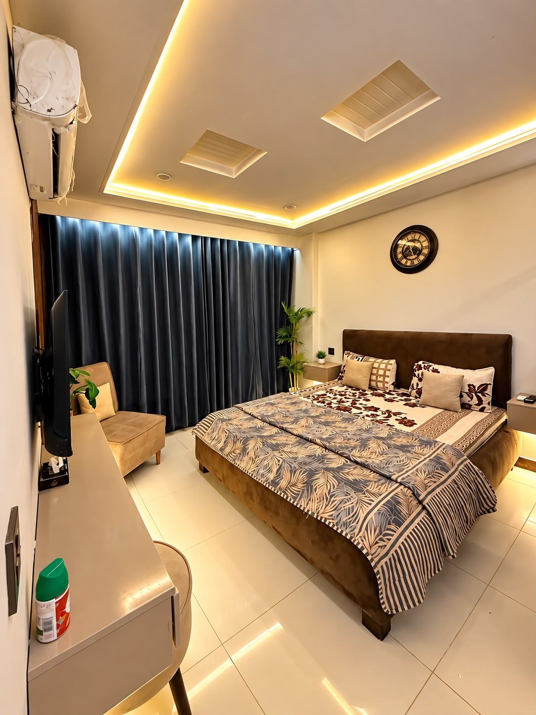 Una camera da letto moderna con un letto grande, un comodino, una sveglia e un lampadario.