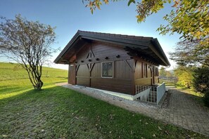 A wooden cabin with a sloped roof, a small porch, and a gravel pathway leading to it. - Country house Kreutzer "Beim Sima" (Rieden)