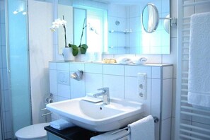 A modern bathroom with a sink, mirror, and toilet. - "Lake in view" in Hagnau on Lake Constance (Hagnau)
