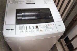 A white Hisense washing machine with a digital display and multiple control buttons. - Ocean Namba (Osaka)