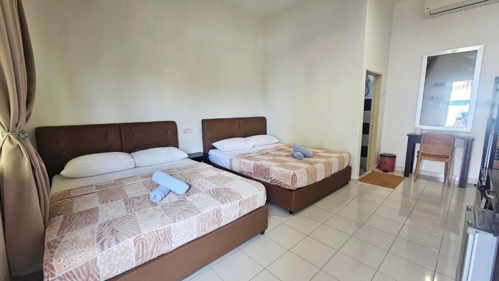 Una habitación de hotel con dos camas, un escritorio y una silla.
