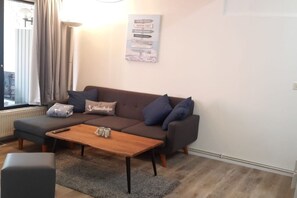 Una sala moderna con un sofá, una mesa de centro y un letrero en la pared.
