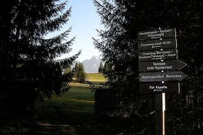 A directional signpost with multiple arrows pointing towards various destinations. - "Schöttelkar" in the Buckelwiesen house (Krün)