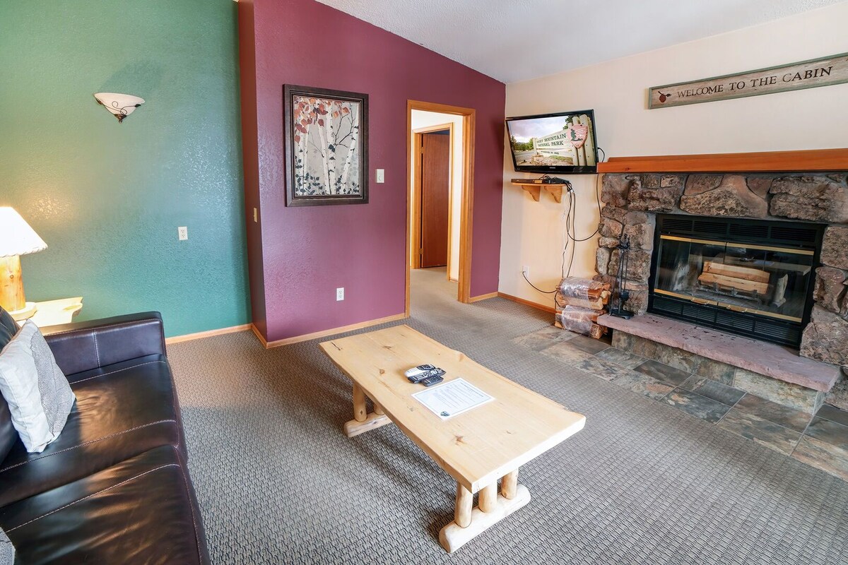 A living room with a fireplace, a television, a couch, and a coffee table.