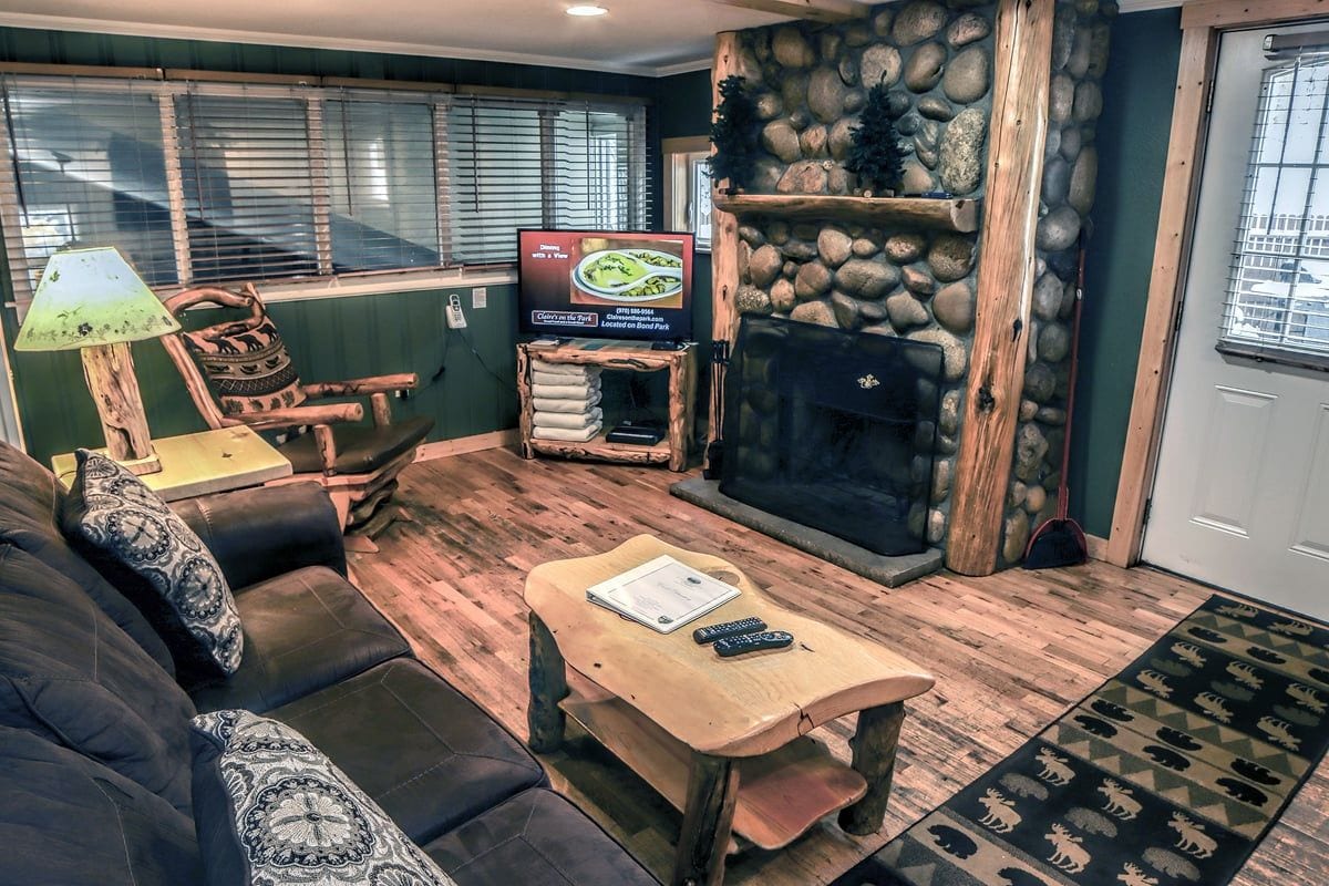 A cozy living room with a fireplace, a television, and a sofa.