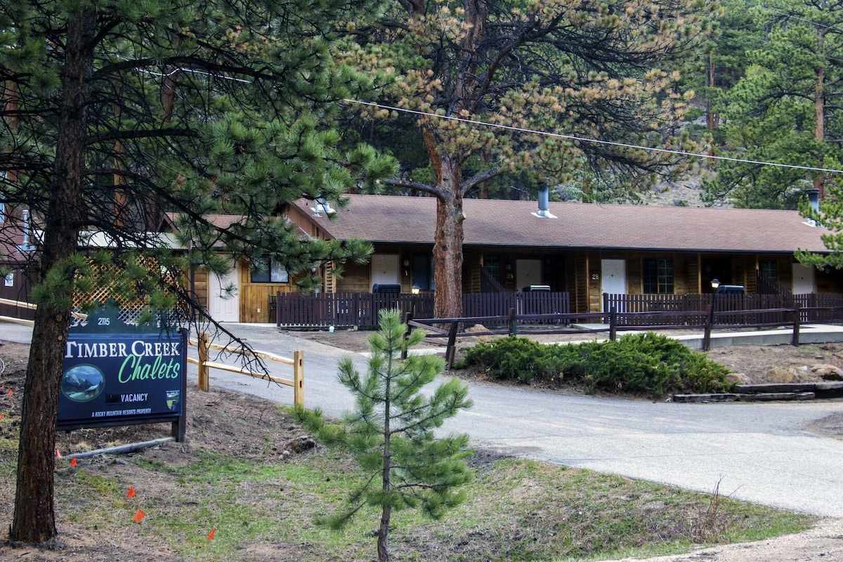 A lodge with a wooden exterior, a covered porch, and a sign advertising vacancies.