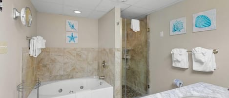 A modern bathroom with a bathtub, shower, and vanity.