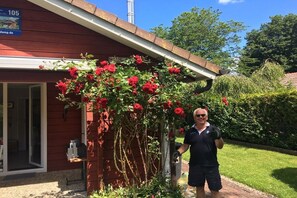A building with a red exterior, a visible door, and a window. - Holiday home House 105 (Damp)
