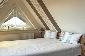 Ein Schlafzimmer mit einem großen Bett, einem Fenster mit Blick und einer Heizung.