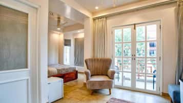 A spacious living room with a large window, a comfortable armchair, and a sofa.