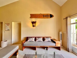 A room with a bed, a wall-mounted light fixture, and a window. - Bazaar Square Lodges - Ylang-Ylang (Upper Floor) (Grand Baie)