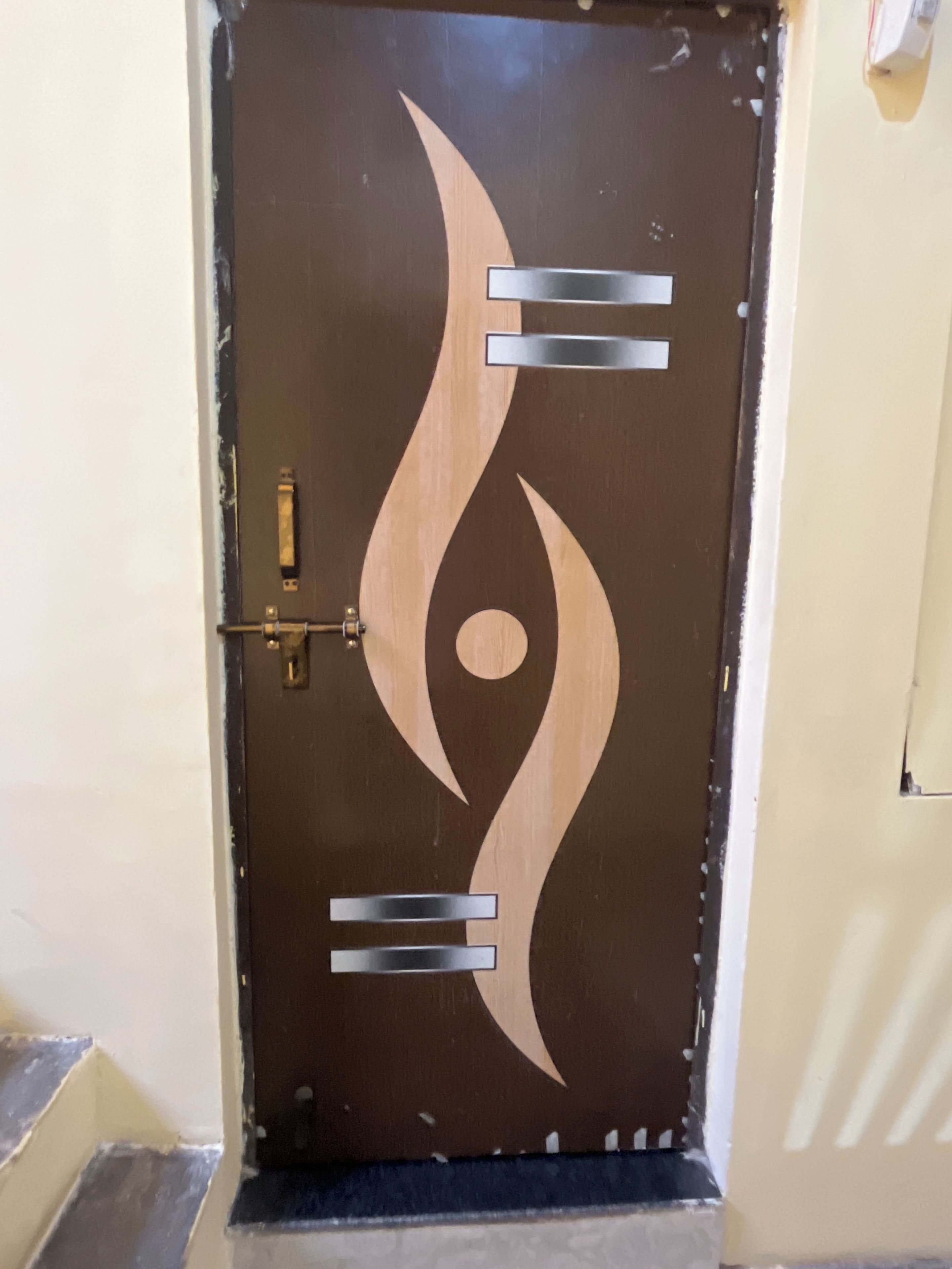 A door with a unique design featuring abstract shapes and a lock mechanism.