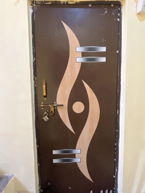 A door with a unique design featuring abstract shapes and a lock mechanism. - 5-bedroom bed & breakfast in brilliant Varanasi with AC (Varanasi)
