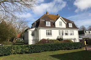 A two-story house with a white exterior, a sloped roof, and a small front porch. - "Villa Friedericia" - Apt. 04 (Wyk auf Föhr)