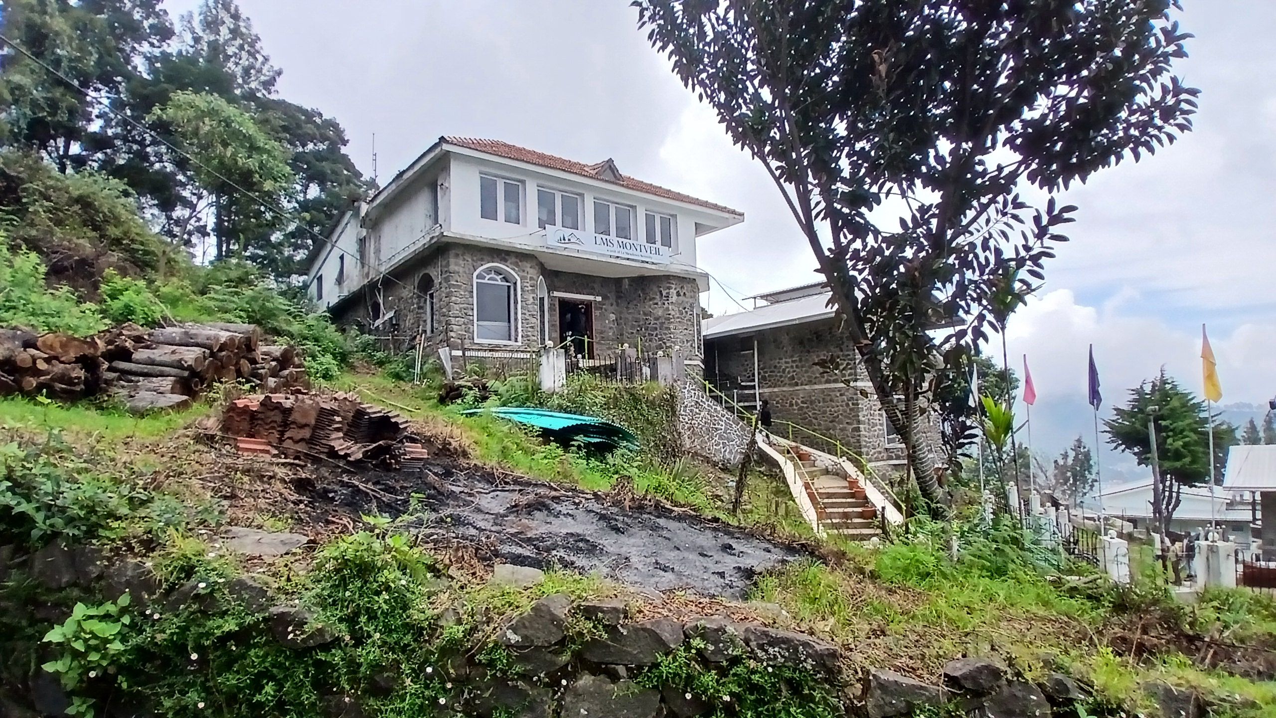 A two-story stone building with a sign reading 'LMS MONTVEIL' and a staircase leading to the entrance.