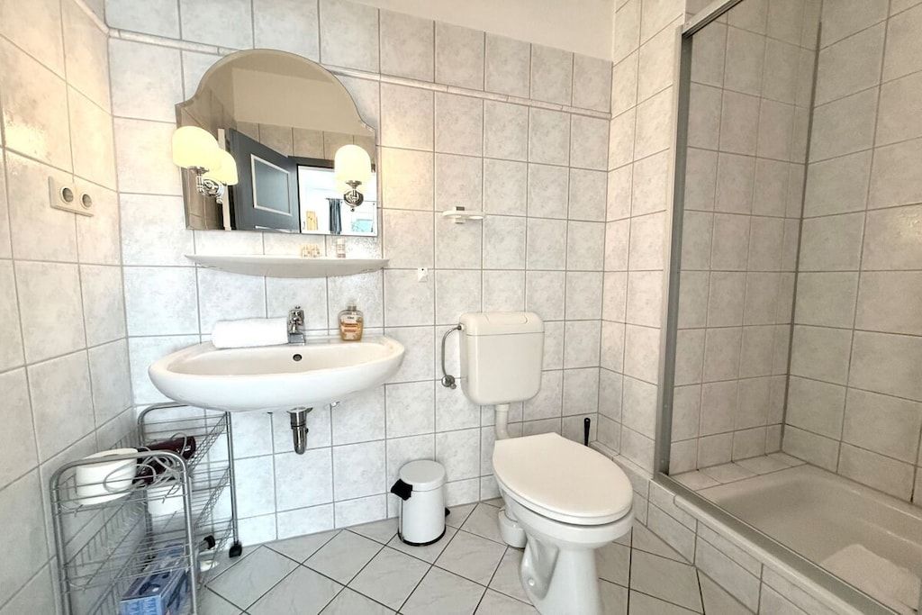 A bathroom with a sink, toilet, and shower.