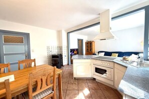 A compact kitchen with a dining area, a built-in oven, and a large window providing natural light. - "Oldsum 2, House 94" (Oldsum)