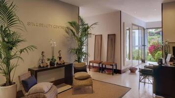 Zona de recepción de un centro de spa y belleza con área de descanso, plantas en macetas y vistas al exterior.