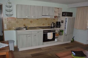 A compact kitchen with a sink, stove, and cabinets. - Holiday apartment with 1 bedroom (Hopferau)