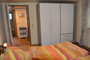 Ein Schlafzimmer mit einem Bett, einem Kleiderschrank und einem kleinen Nachttisch.