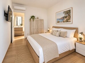A bedroom with a bed, bedside tables, a nightstand, a wardrobe, a mirror, and a framed picture on the wall. - Levante Privé Pool Retreat Salento (Lequile)