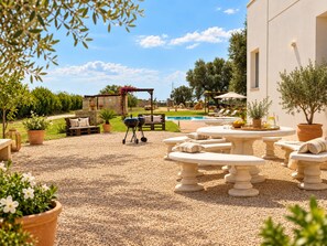 An outdoor patio area with a pool, seating, and a barbecue setup. - Levante Privé Pool Retreat Salento (Lequile)