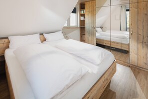Ein Schlafzimmer mit einem großen Bett, einem Holzkopfteil und einem Schrank mit Spiegel.