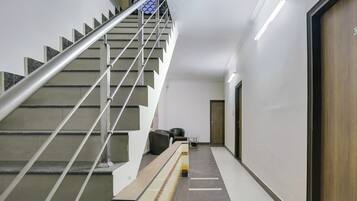 Una escalera moderna con barandas de metal y pasamanos, que conduce a una puerta con el número 3.