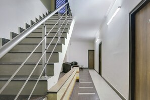 A modern staircase with metal railings and a handrail, leading to a door marked with the number 3.