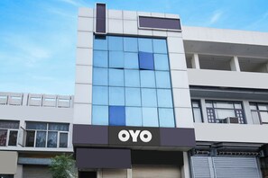 A building with a prominent 'OYO' sign on the facade, featuring a modern design with large windows and a flat roof.