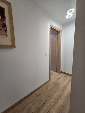 A hallway with a wooden door and a framed picture on the wall. - Holiday Home 'Modern Apartment' with Wi-Fi and Air Conditioning (Θεσσαλονίκη)