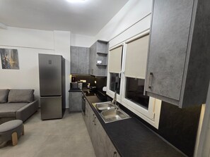 Eine moderne Küche mit einem eingebauten Kühlschrank, einer Mikrowelle und einem Spülbecken.