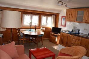 A compact living space with a dining area, kitchenette, and seating area. - Country House Jäger Holiday Apartment No. 1 (Todtnauberg)