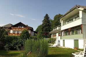 Ein Wohngebiet mit zwei Häusern, eines mit Balkon und das andere mit Veranda.