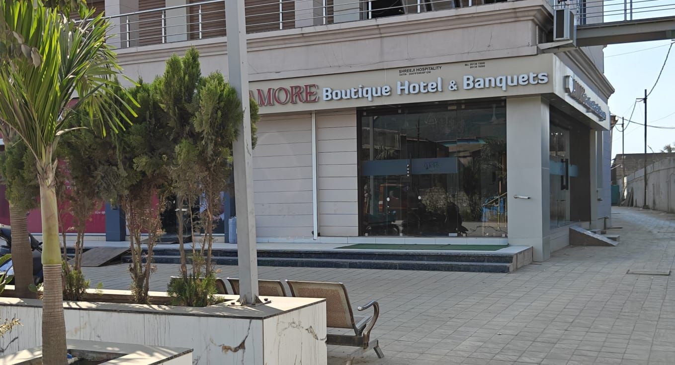 Un edificio con un letrero que dice 'MORE Boutique Hotel & Banquets', con un diseño moderno y una entrada visible.