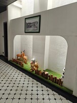 Un pasillo con una exhibición decorativa que incluye un cuadro enmarco, un ciervo, un perro y un panda.