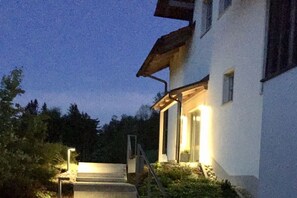 A building with a staircase leading to a door, surrounded by greenery. - Holiday apartment with 1 bedroom (Breitenberg)