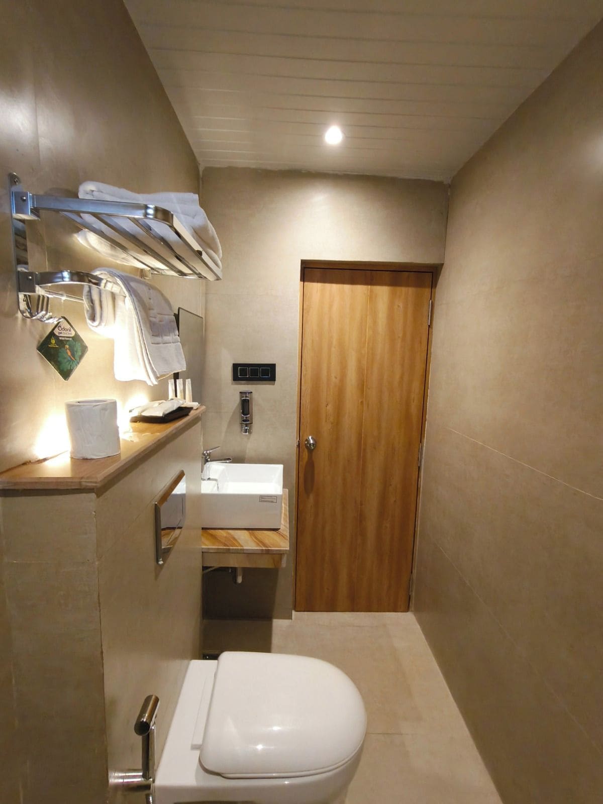A modern bathroom with a toilet, sink, and towel rack.