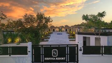 A gated entrance to a resort with a clear pathway leading to multiple buildings.