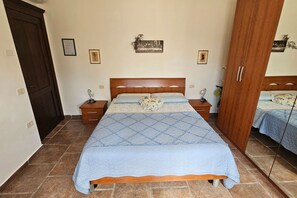 A bedroom with a bed, two bedside tables, a wardrobe, and a mirror. - Apartment Roggiano Tuscan countryside with pool (Scansano)