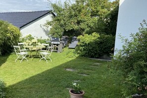 A backyard with a dining table and chairs, a barbecue grill, and a potted plant. - Holiday apartment in Salem with swimming pool (Salem)