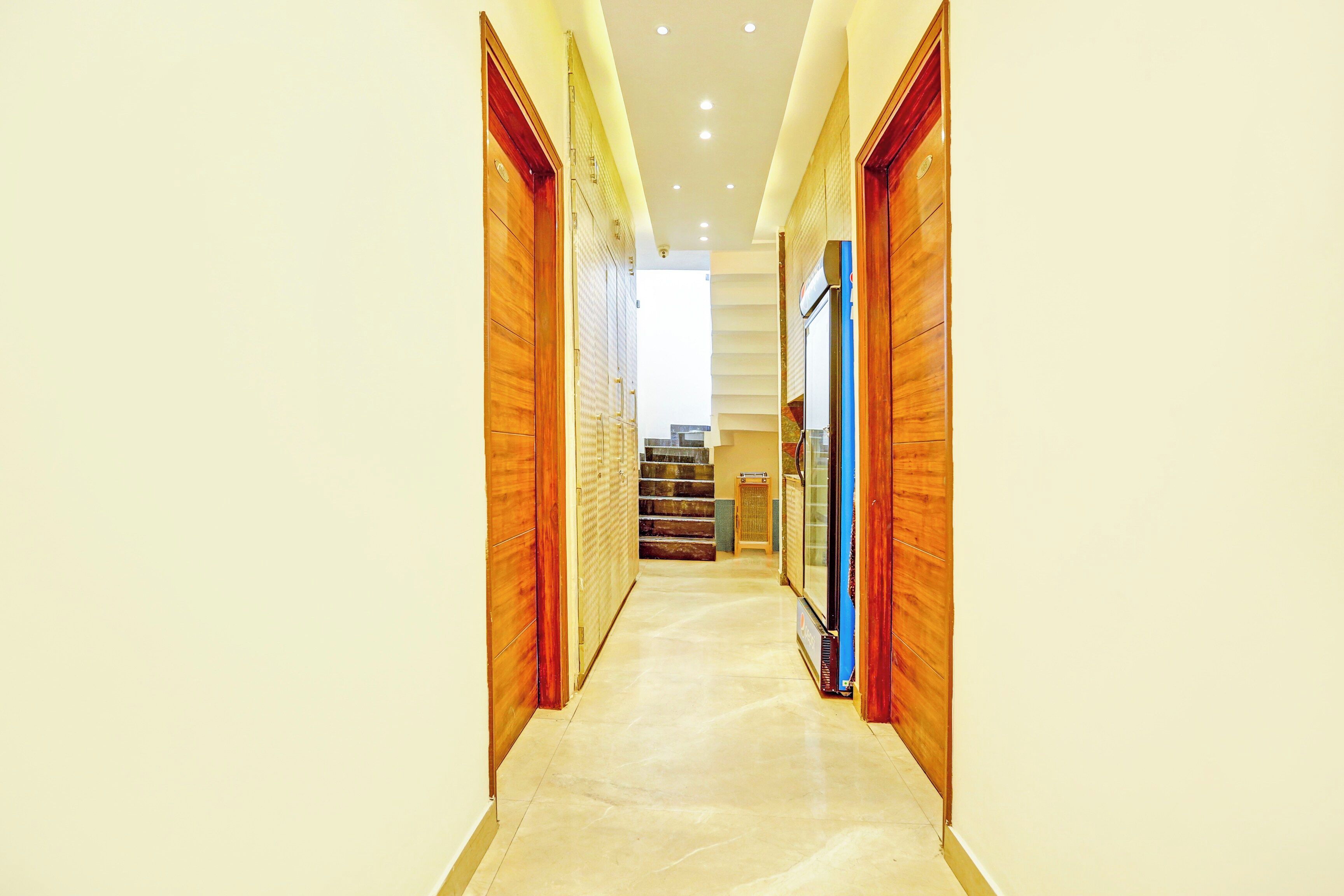 A corridor with wooden doors leading to a staircase.
