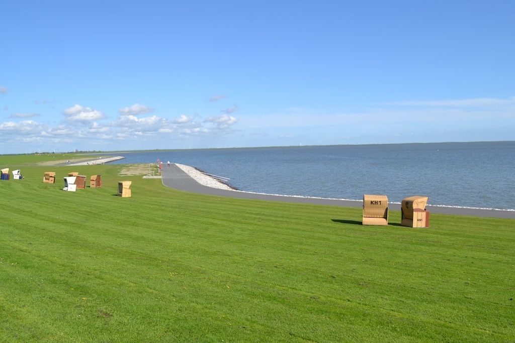 A grassy area with a body of water, a jetty, and several cardboard boxes labeled 'KH1'.