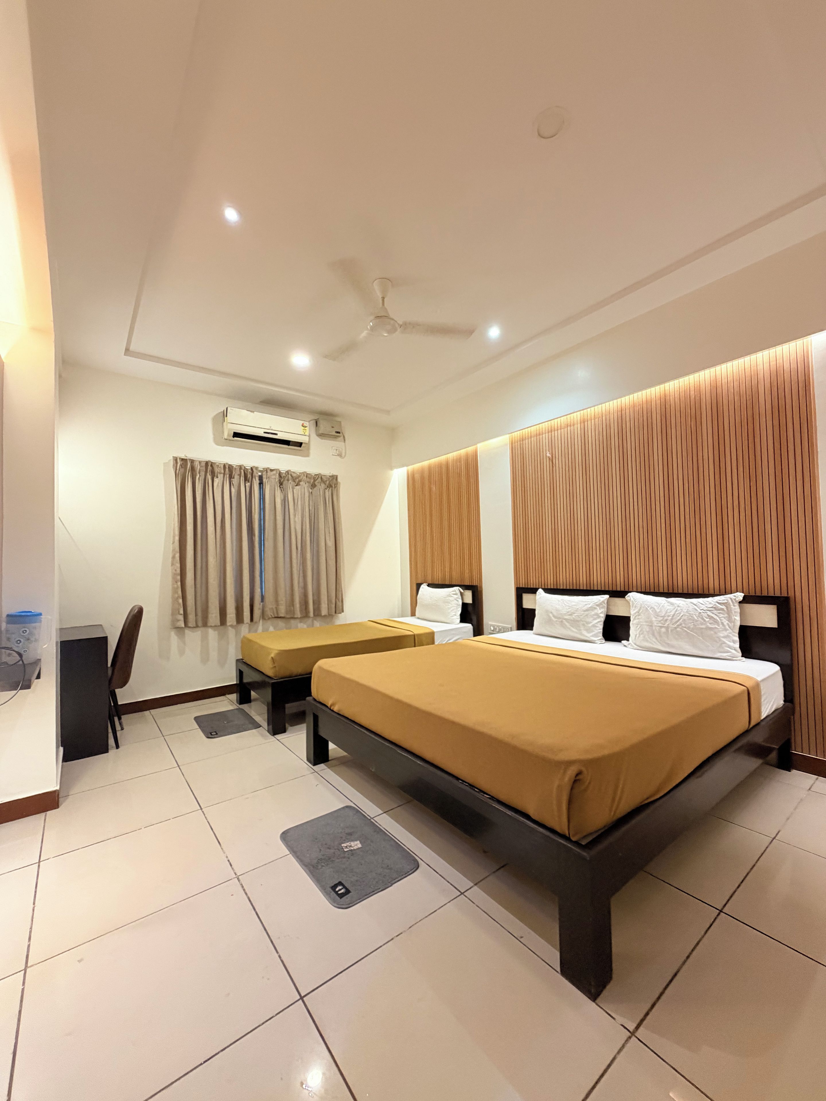 A hotel room with a large bed, a desk, and a chair.