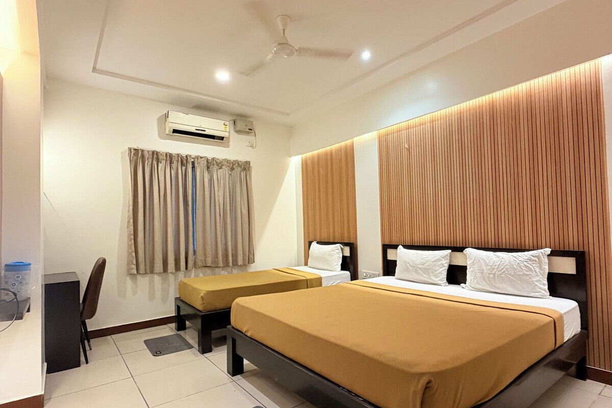 A hotel room with a large bed, a desk, and a chair.