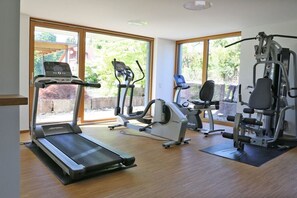 Ein Fitnessraum mit Laufband, Crosstrainer und Kraftmaschine.